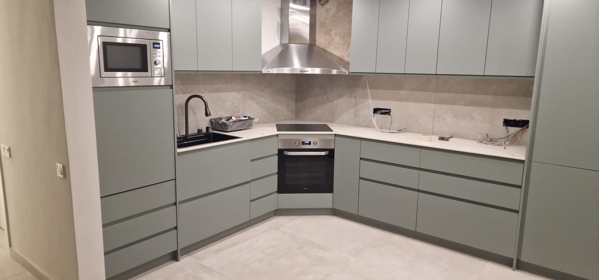 Mobiliario verde mate con apertura mediante gola Construcción de cocina en Vallirana | Cocina moderna en vivienda unifamiliar Mobiliario verde mate con apertura mediante gola